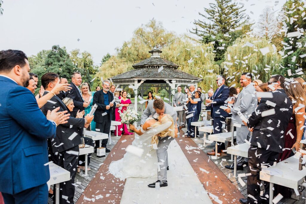 Groom dips bride during Flowerfield wedding ceremony recessional.